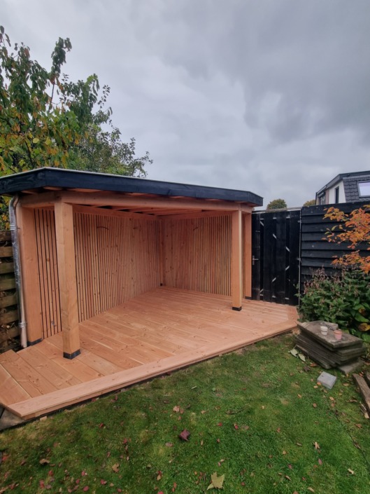 Houten overkapping op maat met plat dak en douglas vlondervloer in de tuin