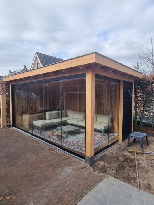 Moderne tuinkamer op maat met glazen schuifwanden, plat dak en loungeset